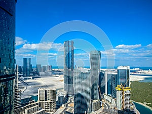 Epic top view shot of Al Reem island towers and landscape with a cloudy blue sky