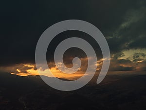 Epic wanderlust scene of a mountain glowing by sunlight at twilight dramatic sky