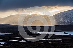 Epic Winter landscape image of view along Rannoch Moor during heavy rainfall giving misty look to the scene