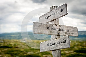 epidemic pandemic outbreak text engraved on old wooden signpost outdoors in nature