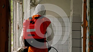 Epidemiologist sprays tick repellent in shower room closeup