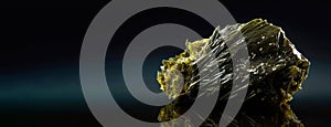 Epidote is a rare precious natural stone on a black background. AI generated. Header banner mockup with space.