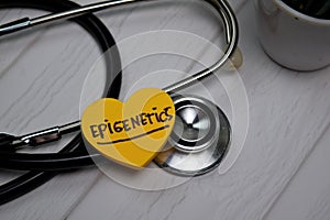 Epigenetics write on sticky note isolated on wooden table. Medical concept photo