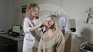 Epilepsy, autism, head injury management. Female nurse helps to prepare patient for EEG test. Doctor in hospital doing