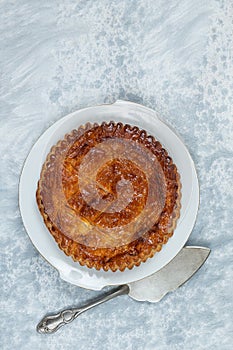 Epiphany Twelfth Night cake french galette des rois made of puff pastry, with the charm inside on a plate top view wirg
