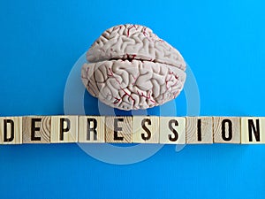 epression is written with wooden cubes on table and human brain