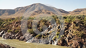 Epupa Falls Waterfall with Baobab trees at the border of Namibia and Angola in Kaokoland, Southern Africa. photo