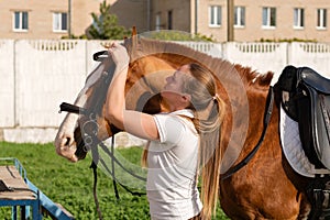 Equestrian adjusting bridle on horse