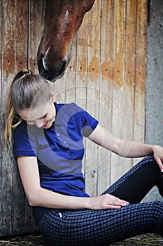Equestrian girl and horse in stable