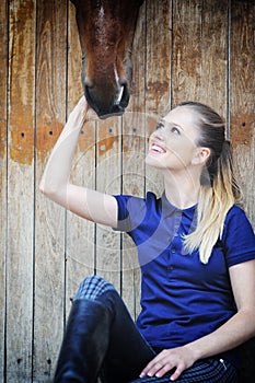 Equestrian girl and horse in stable