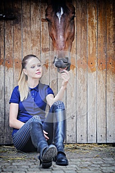 Equestrian girl and horse in stable