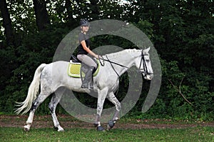 Equestrian girl on horseback trail riding