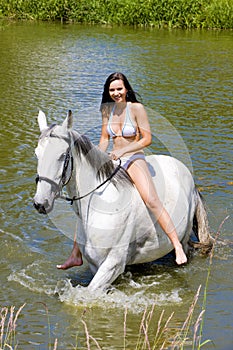 equestrian on horseback riding through water