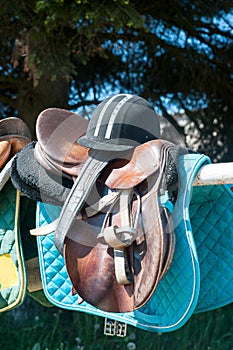 Equestrian sport equipment and accessories hanging on fence