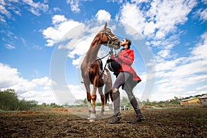 Equestrian sport, young woman jockey is riding brown horse