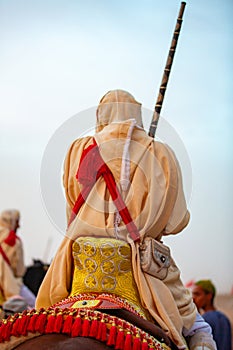 Equestrians participating in a traditional fancy event named Tbourida dressed in a traditional Moroccan outfit photo