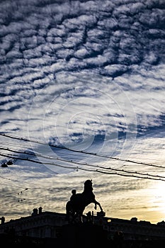 Equine horse sculpture silhouette on a blue cloudy sky