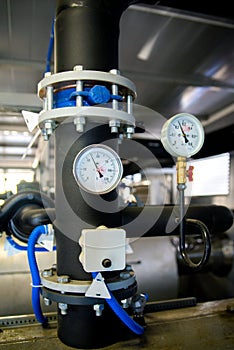 The equipment of the boiler-house, valves, tubes, pressure gauges, thermometer. Close up of manometer, pipe, flow meter, water