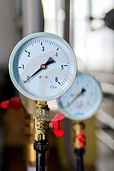 The equipment of the boiler-house, - valves, tubes, pressure gauges, thermometer. Close up of manometer, pipe, flow meter, water