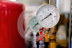 The equipment of the boiler-house, - valves, tubes, pressure gauges, thermometer. Close up of manometer, pipe, flow meter, water