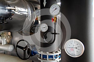 The equipment of the boiler-house, - valves, tubes, pressure gauges, thermometer. Close up of manometer, pipe, flow meter, water