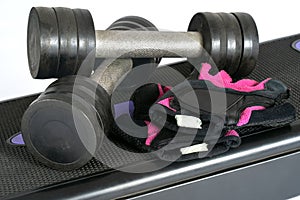Equipment for effective gym exercises, used dumbbells and protective gloves.