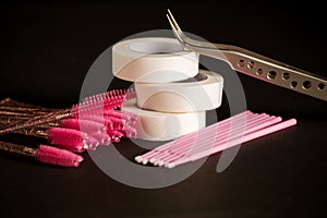 Equipment for eyelash extensions on a dark background.