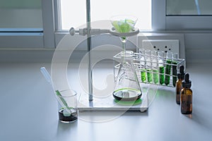 Equipment and glassware for test the natural product extraction and green color solution, in the chemistry laboratory.