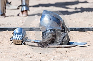 Equipment knight - the participant in the knight festival - shield, sword, helmet and glove lie on the ground near the lists