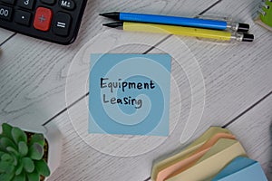 Equipment Leasing write on sticky notes isolated on Wooden Table photo