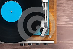 Equipment for listening to vinyl records on a brown table, top view