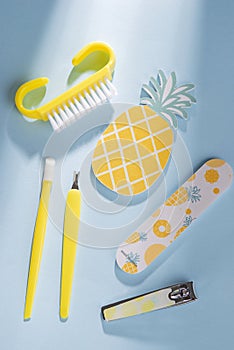 Equipment for manicure or pedicure, spa on blue background with hard light, travel set of pineapples and tropics