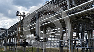 The equipment of oil refining. Close-up of industrial pipelines of an oil-refinery plant. Detail of oil pipeline with valves in