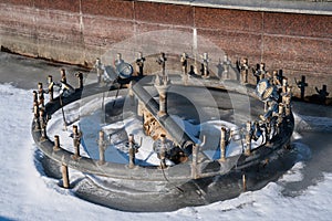 equipment with pipes and taps with illumination in an empty fountain in winter