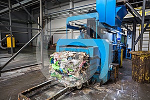 Equipment for pressing debris sorting material to be processed in modern waste recycling plant. garbage press on modern waste