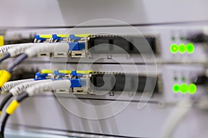 Equipment of radio base station close-up, blue and yellow optic patch cords.