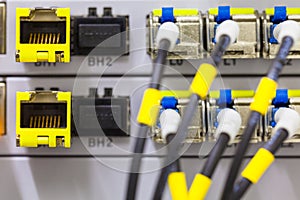 Equipment of radio base station close-up, blue and yellow optic patch cords.