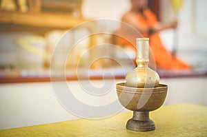 The equipment used in the rituals of Buddhism by the priests yellow dress, orange is the background blurred.