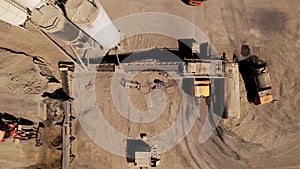 Equipment works at a crushed stone quarry, aerial view. Conveyor and production of construction gravel and sand. Mining