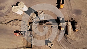 Equipment works at a crushed stone quarry, aerial view. Conveyor and production of construction gravel and sand. Mining