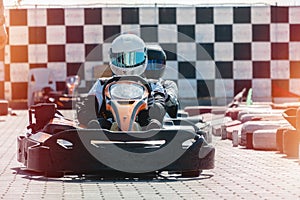 Equipped drivers are sitting in a racing car. Ready for battle, championship. Go karts racing, sreet extreme sport. fun