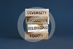 Equity, diversity, inclusion and belonging symbol. Wooden blocks with words `equity, diversity, inclusion, belonging` on beautif photo