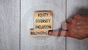 Equity, diversity, inclusion and belonging symbol. Wooden blocks with words `equity, diversity, inclusion, belonging` on beautif