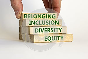 Equity, diversity, inclusion and belonging symbol. Wooden blocks with words `equity, diversity, inclusion, belonging` on beautif