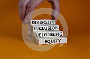 Equity, diversity, inclusion and belonging symbol. Wooden blocks with words `equity, diversity, inclusion, belonging` on beautif