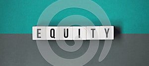 equity word on wooden cubes. Concept of investment and savings money. Wooden blocks with letters isolated on orange background