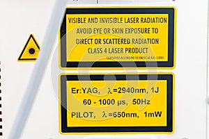 ER:Yag laser machine safety label, on side of device, in yellow and black, with warnings and specifications of laser wavelengths