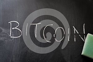 Erasing bitcoin, hand written word on blackboard being erased concept