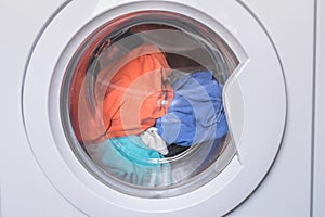 Erasing home t-shirts. Dirty clothes are inside the washing machine. Automatic washer with open door