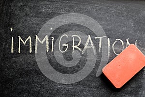 Erasing immigration, hand written word on blackboard being erased